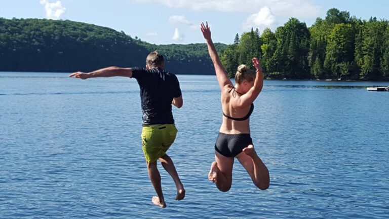 Guests jumping into Mountain Lake, one of the summer resort activities at Ogopogo Resort